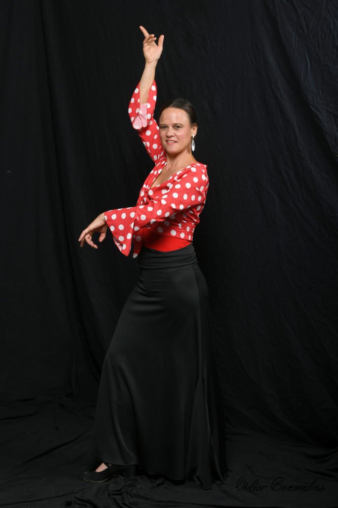 photo en studio de 1 danseuse flamenco le fond est noir elle une 
chemise rouge à pois blanc et un pantalon noir  la danseuse est très souriante elle a été photographier par Didier Bezombes photographe à Rodez en Aveyron