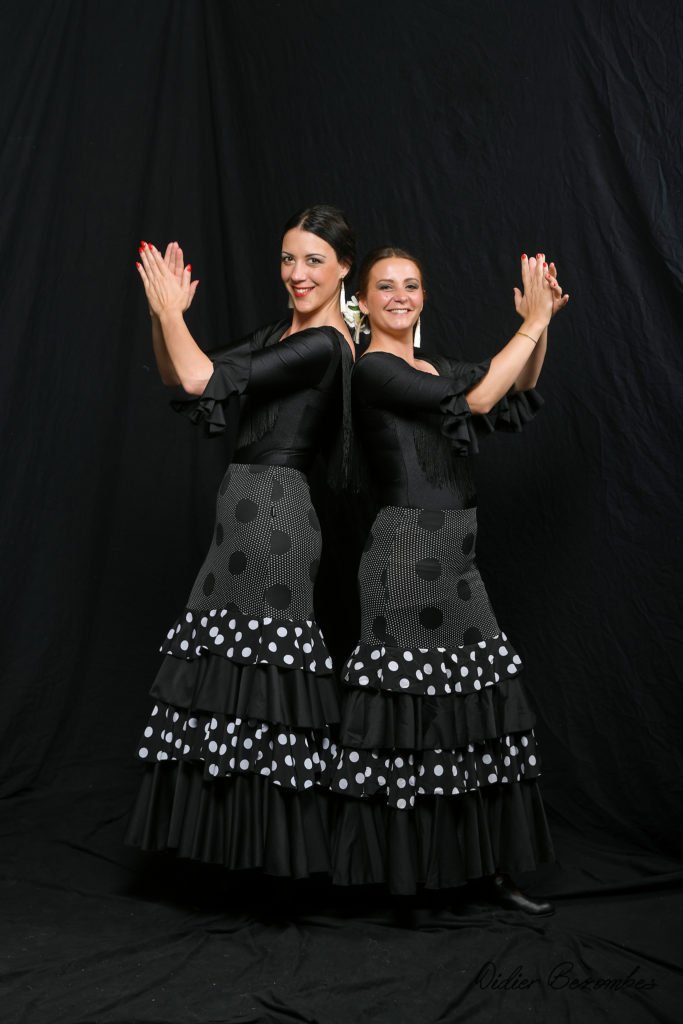 photo en studio de 2 danseuses de flamenco le fond est noir elles on 
robes noir et blanche et un pantalon noir  la danseuse est très souriante elle a été photographier par Didier Bezombes photographe à Rodez en Aveyron